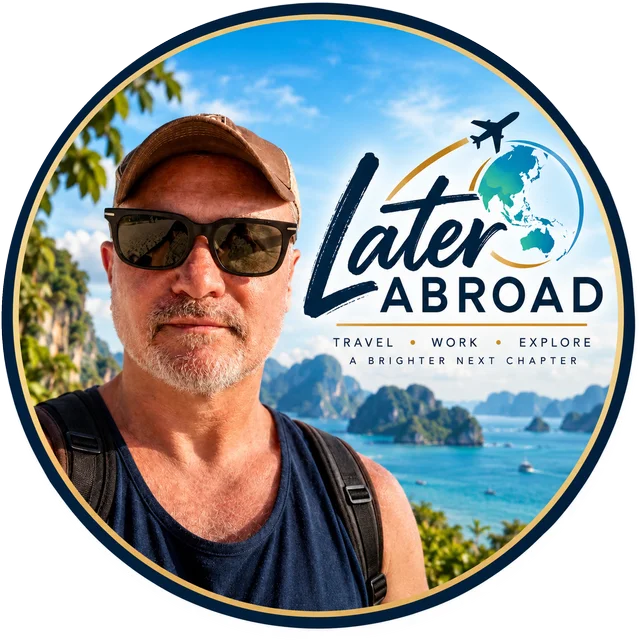 Later Abroad badge: Joel in sunglasses above a tropical bay, with the line Travel, Work, Explore. A brighter next chapter.